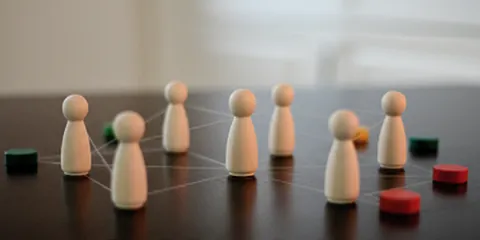Holzfiguren zeigen eine systemische Aufstellung auf einem Tisch.
