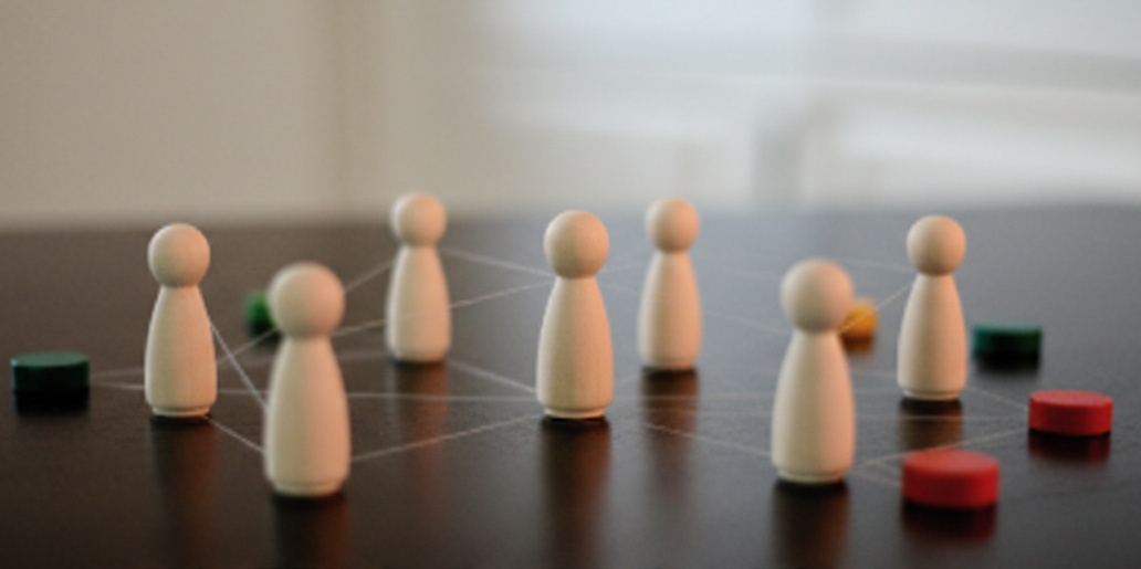 Holzfiguren zeigen eine systemische Aufstellung auf einem Tisch.